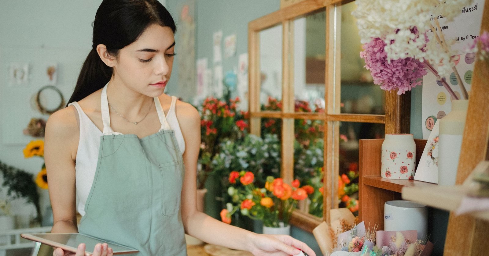 Small business owner using a tablet in her flower shop